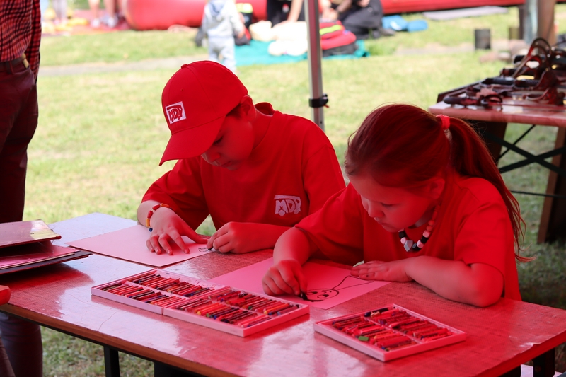 chłopiec i dziewczynka rysują na kartkach obrazki