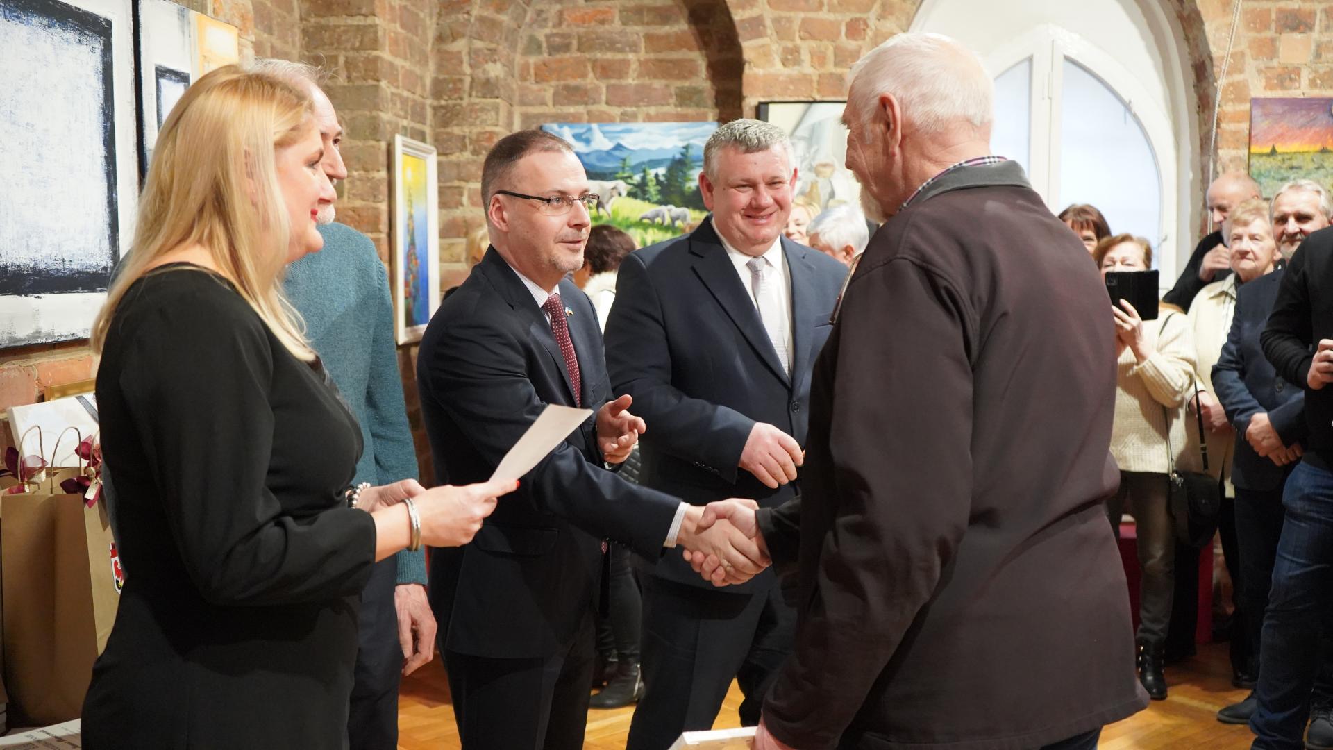 Dyrektor muzeum wręcza nagrodę rzeźbiarzowi, Burmistrz podaje mu dłoń