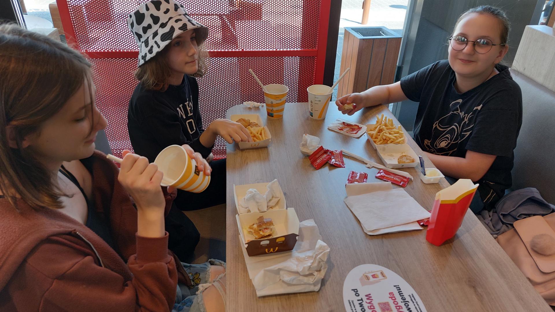 trzy dziewczynkie jedza fast-food`y