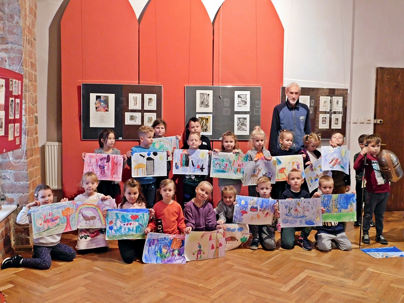 grupa dzieci pozuje do zdjęcia ze swoimi rysunkami